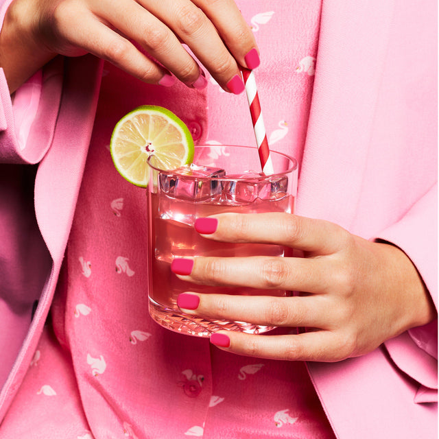 Cocktail served in the Old Fashion Glass with a slice of lemon and pink & white striped straw.